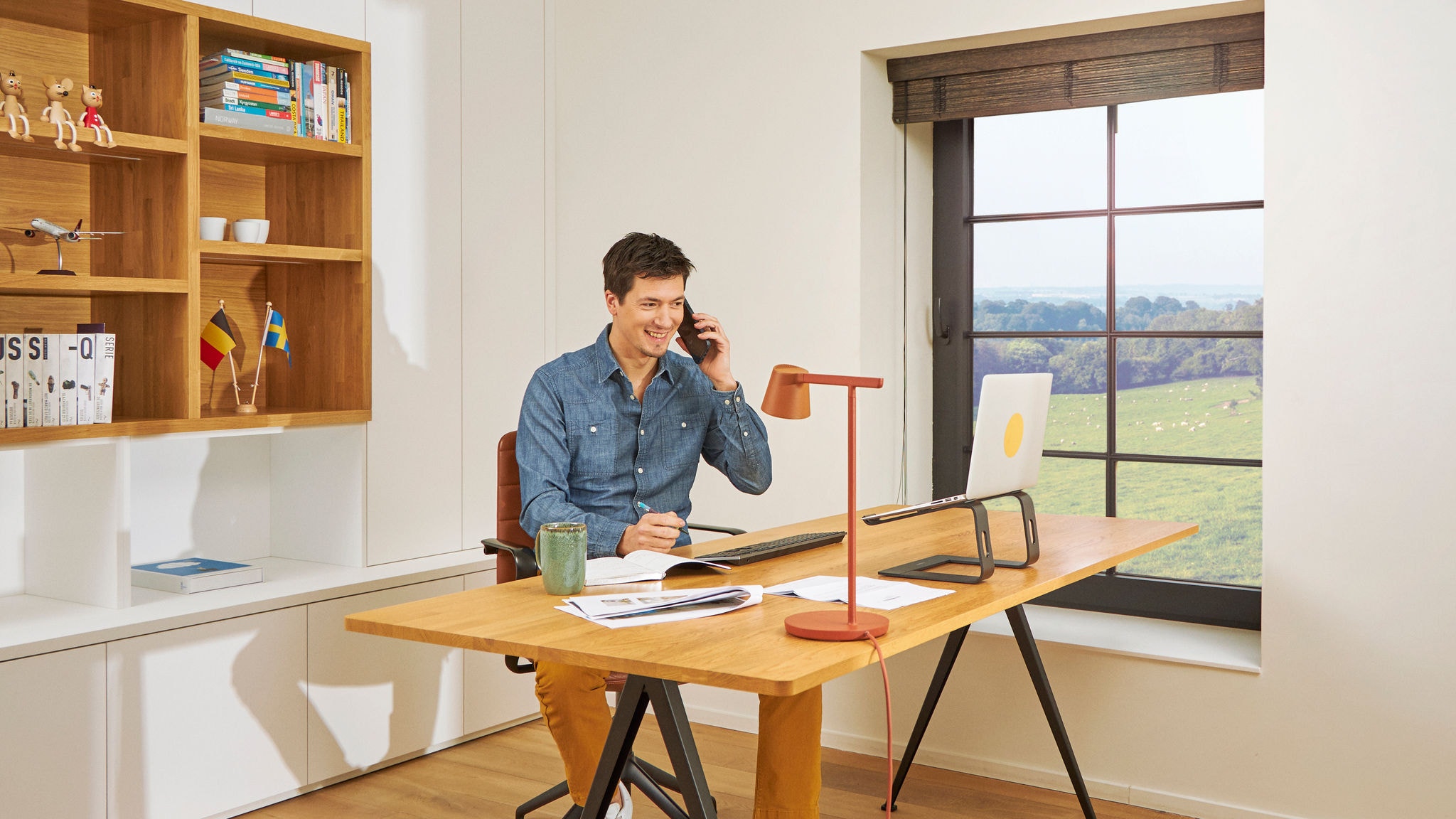 Mann telefoniert am Schreibtisch im Heimbüro bei bester Raumluftqualität