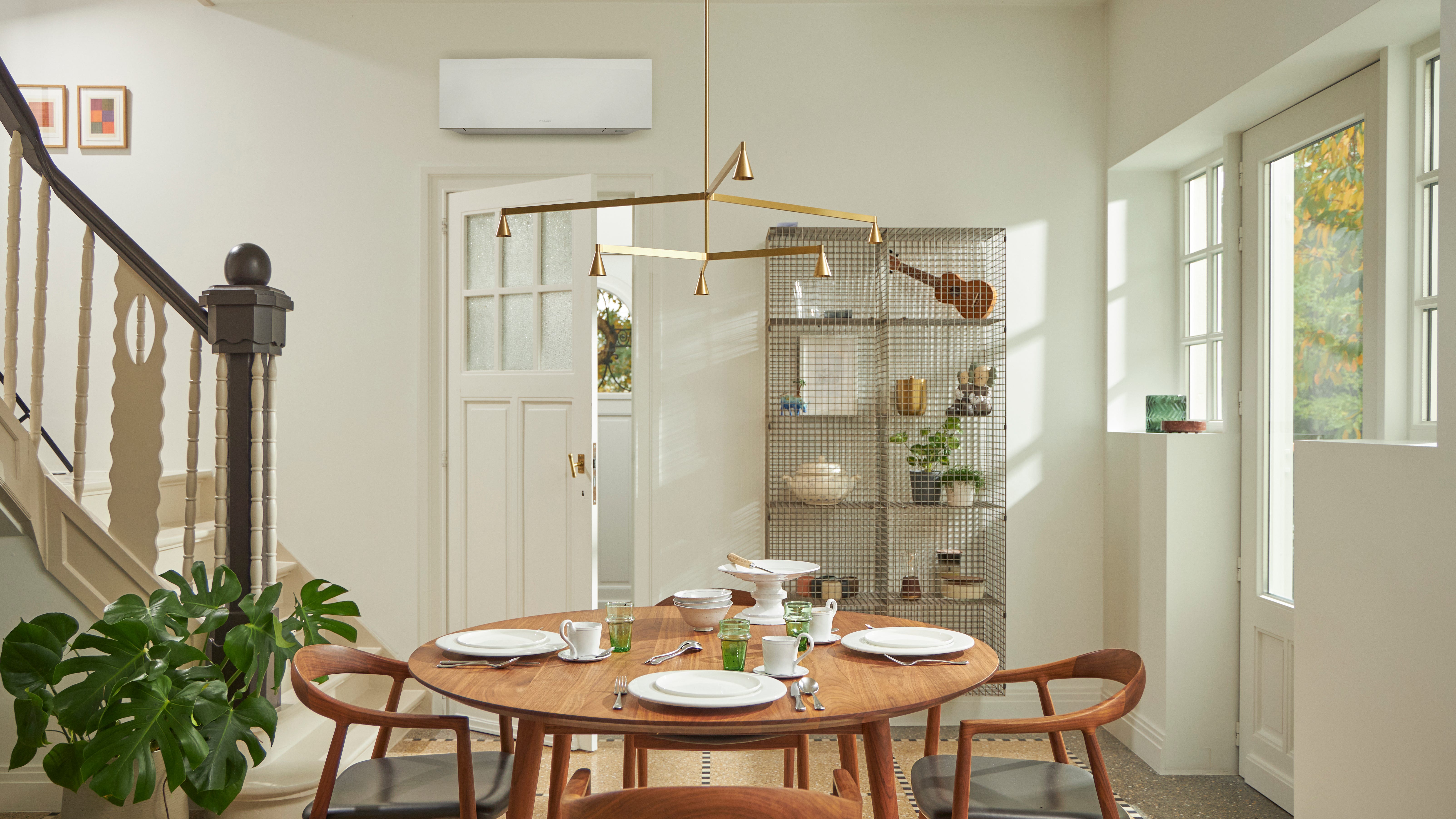 Zimmer mit großem Fenster, Holztisch und schwarzer, wandmontierter Klimalösung