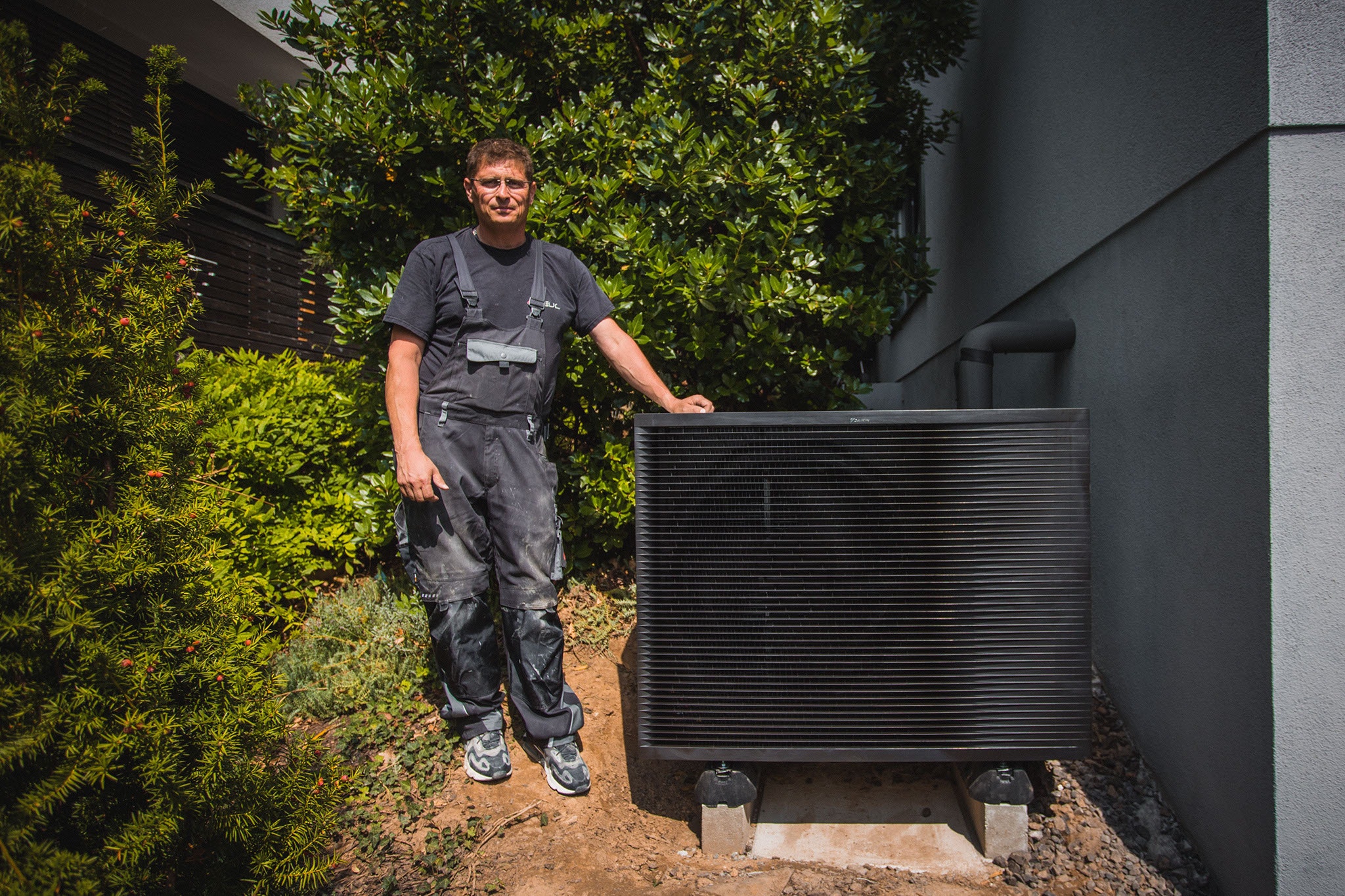 Monteur neben installiertem Außengerät der DAIKIN Altherma
